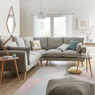 white living room with grey sofa and wooden flooring