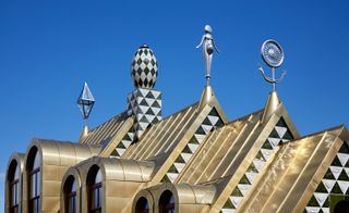 Three spires and a chequered chimney adorn its glistening golden roof