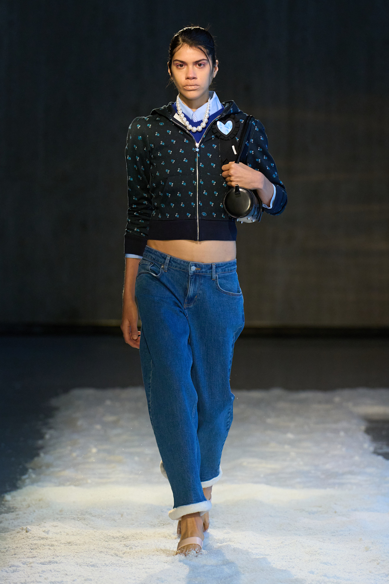 Woman in sweater and low-rise jeans on the Sandy Liang F/W 25 runway