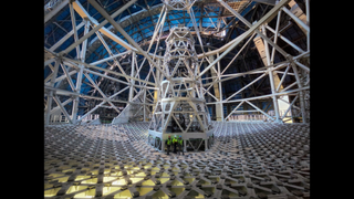 Workers stand near the base of the Extremely Large Telescope.