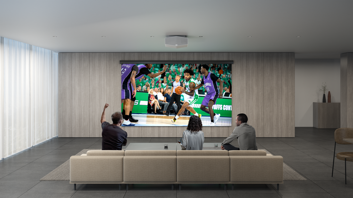 Sony VPL-XW7000ES projector in living room, showing basketball while 3 people watch from the sofa