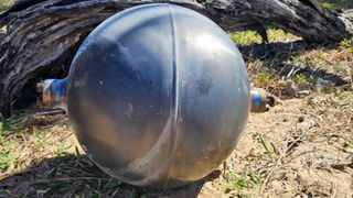 a metallic sphere on a sandy beach