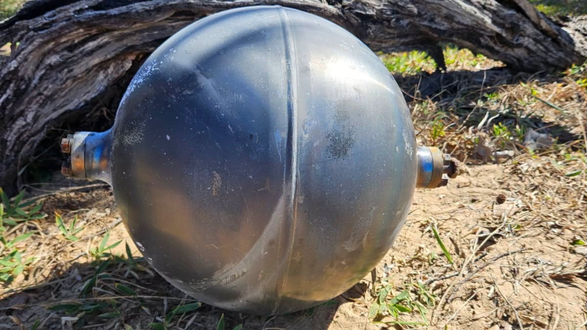 a metallic sphere on a sandy beach