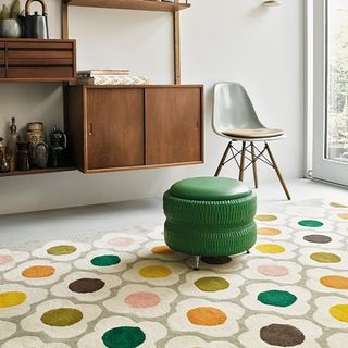 Retro orla kiely rug in primary colours in a living room with mid century furniture.