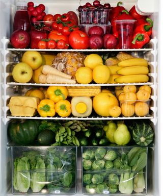 Three rows of fruit and veg inside a fridge stacked like a rainbow very aesthetically with greens on the bottom, yellows in the middle, and reds on top