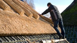 A man thatching a roof