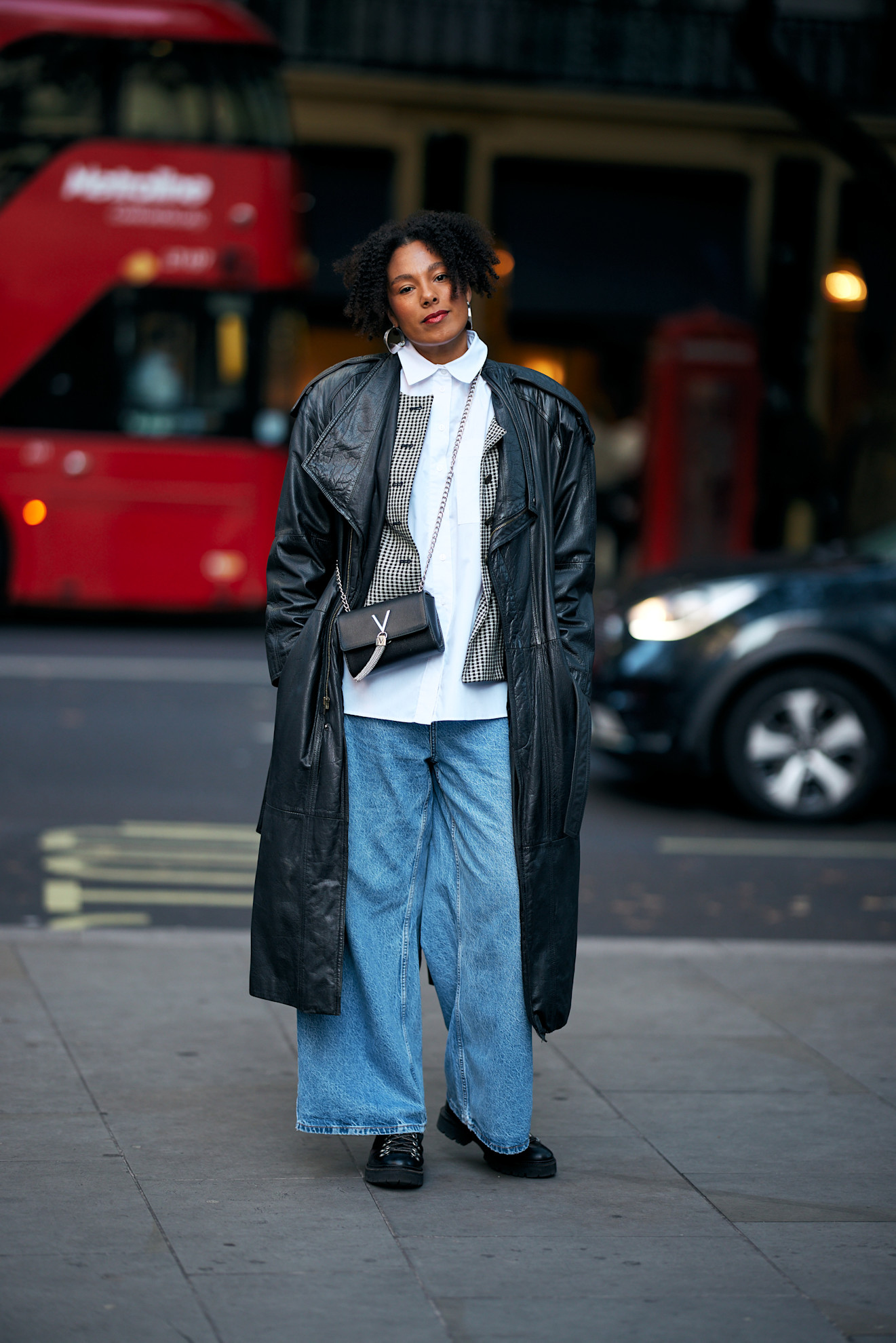 woman wearing a black leather trench coat, jeans, and boots