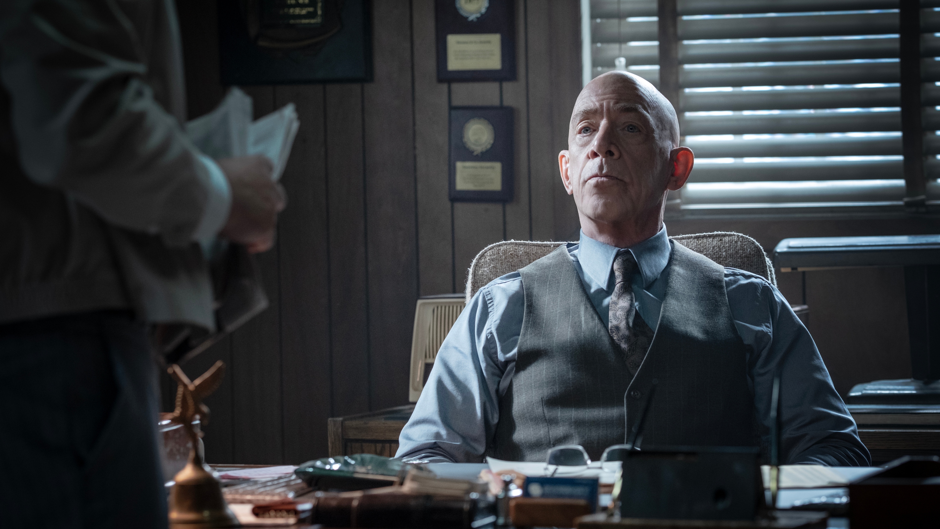 J.K. Simmons as Eamon Sweeney sitting at a desk in a detective's office.