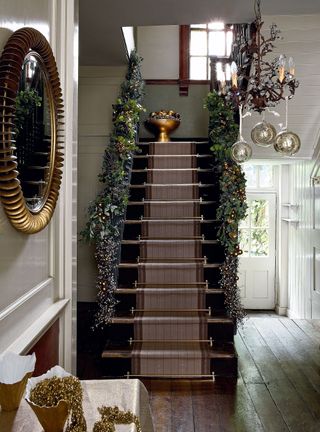 Christmas stair decor ideas with snow dusted garland and chandelier