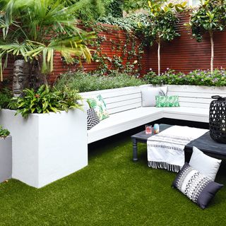 garden with green lawn foliage and cushions