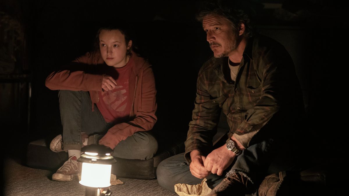 Ellie (Bella Ramsey) and Joel (Pedro Pascal) lit by a camp lantern in The Last Of Us episode 5