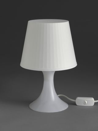 The Lampan lamp by IKEA, made of white plastic and consisting of a simple lampshade and base for easy transportation