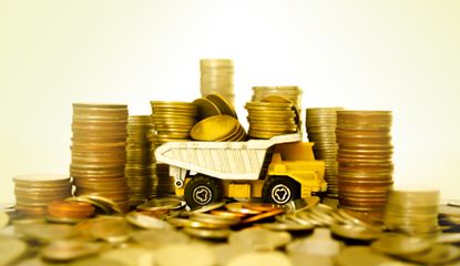yellow toy dump truck holding and surrounded by piles of gold coins