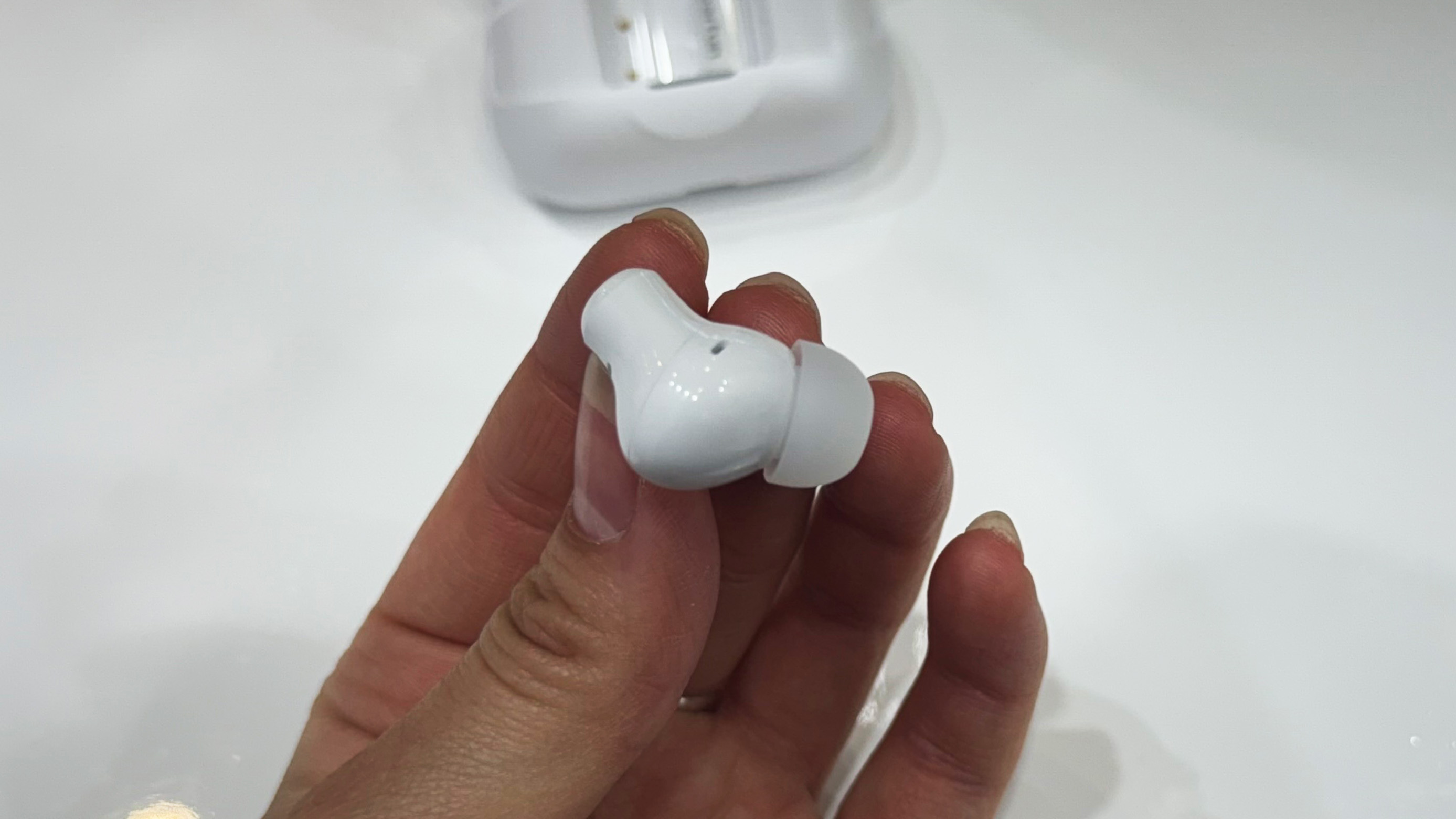 the earfun air pro 4+ earbuds in white showing the charging case, angled fit, and silicone ear tips