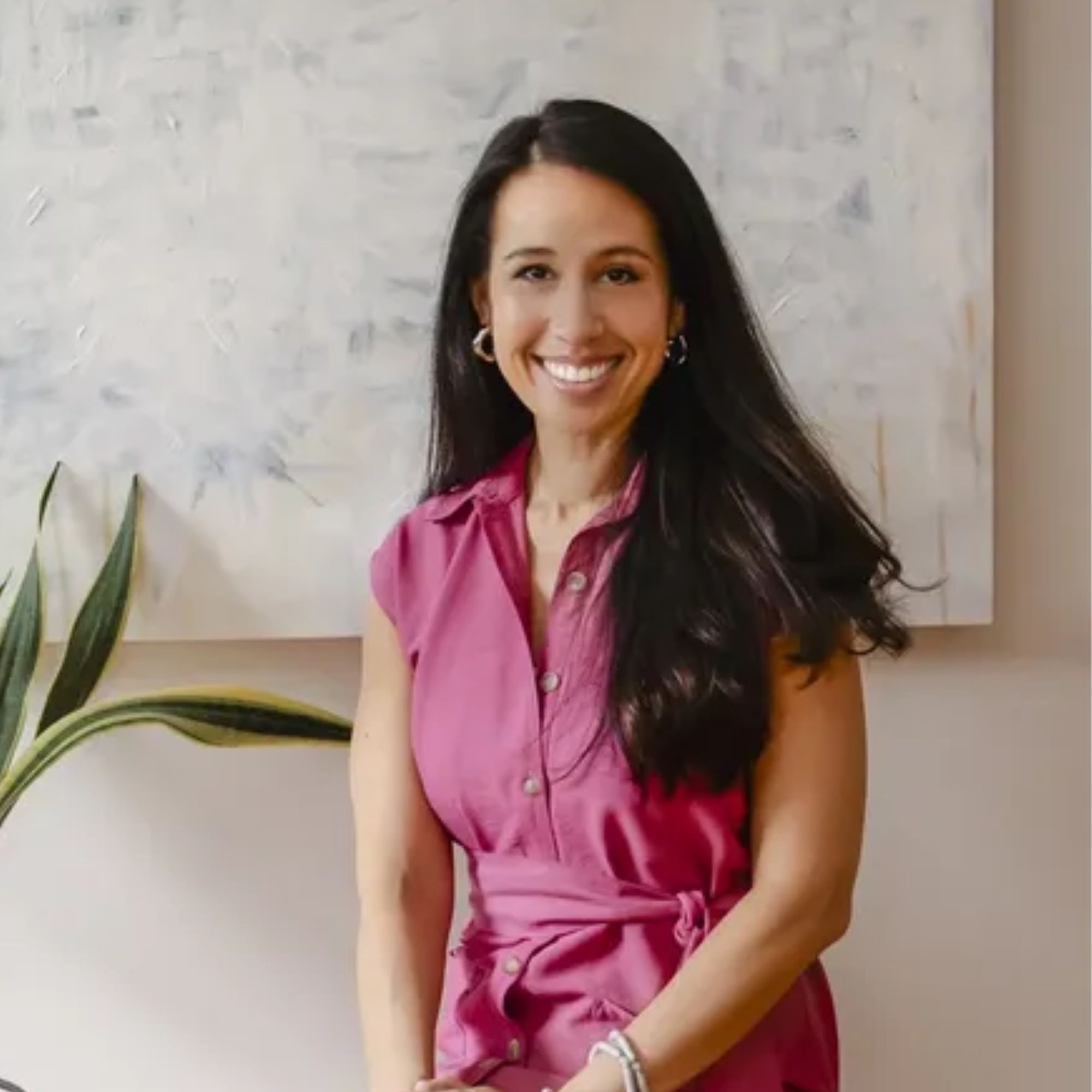 woman with black hair and pink dress smiling at camera 