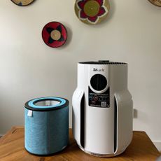 Shark NeverChange 5 Air Purifier sitting on a wooden table with the filter next to it