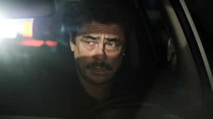 A screenshot of Benicio Del Toro's Kyle Kaplan with light streaming across his eyes in Reptile, one of the new Netflix movies