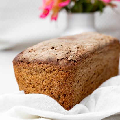 baked bread with white flower vase and white fabric