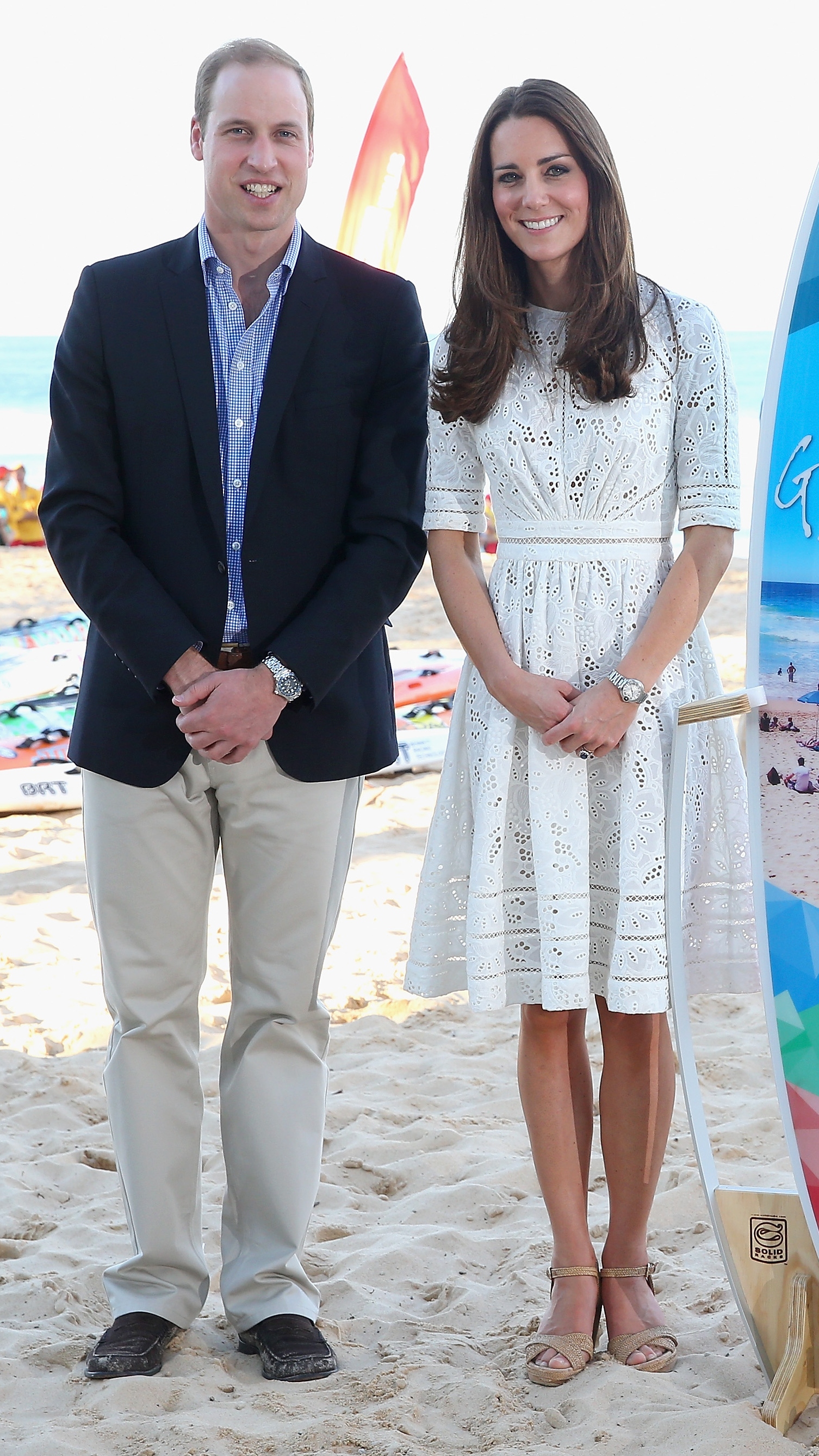 Catherine and Prince William pose with a surfboard they were given as they attend a lifesaving event on Manley Beach on April 18, 2014 in Sydney