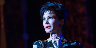 Judy Garland (Renee Zellweger) holds a microphone and stands on stage in Judy