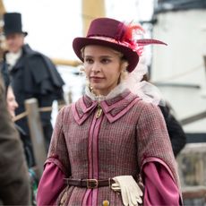 A woman (Iola Evans as Tanna) wearing an 1837 travel outfit while disembarking a boat, in 'Washington Black.'