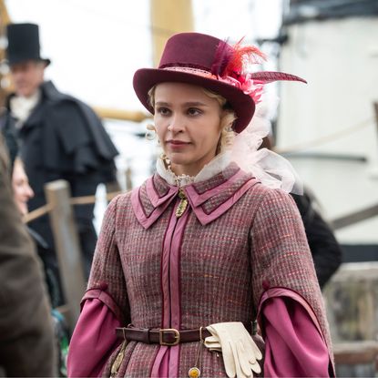 A woman (Iola Evans as Tanna) wearing an 1837 travel outfit while disembarking a boat, in 'Washington Black.'