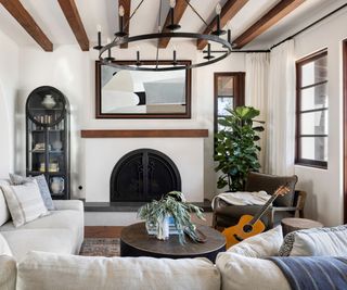California casual style living room with exposed wooden ceiling beams, white walls and hints of blue and green through the decorative items and soft furnishings