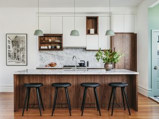 Californian kitchen with wooden cabinets and marble splashback by Banner Day Interiors