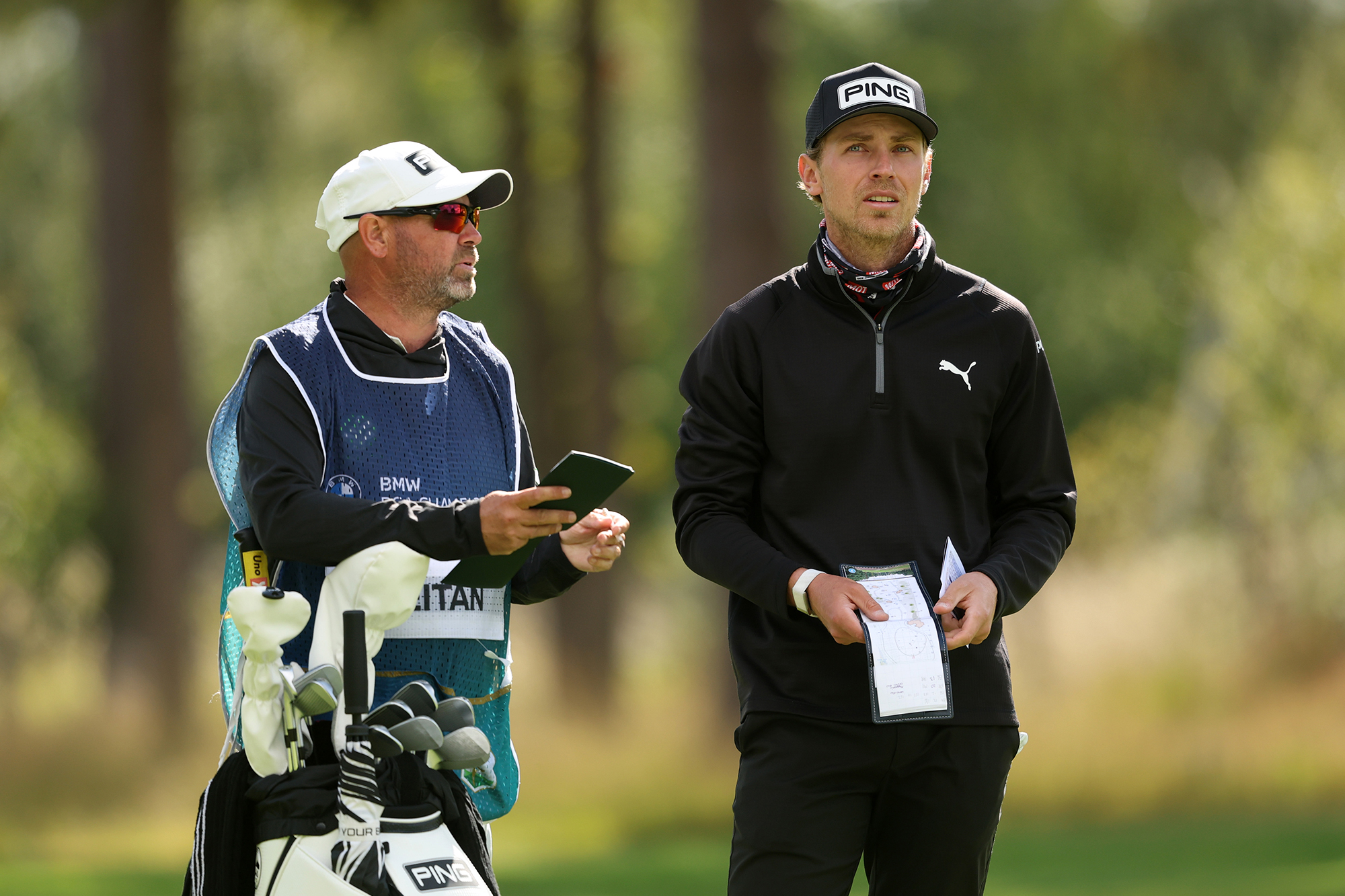 Kristoffer Reitan talking to his caddie with his yardage book at the BMW PGA Championship