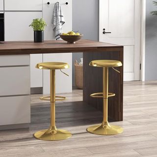 Two gold barstools next to a wooden kitchen island