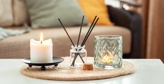 Living room coffee table with scented candle and diffuser to show examples of scent-scaping a living room