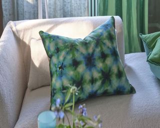 Patterned blue and green cushion on cream boucle sofa
