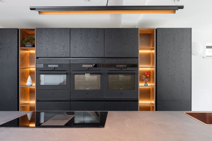 The new kitchen island and oven worktop with black front and state-of-the-art appliances