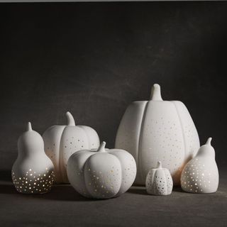 Six porcelain pumpkins and gourds with small glowing piercings