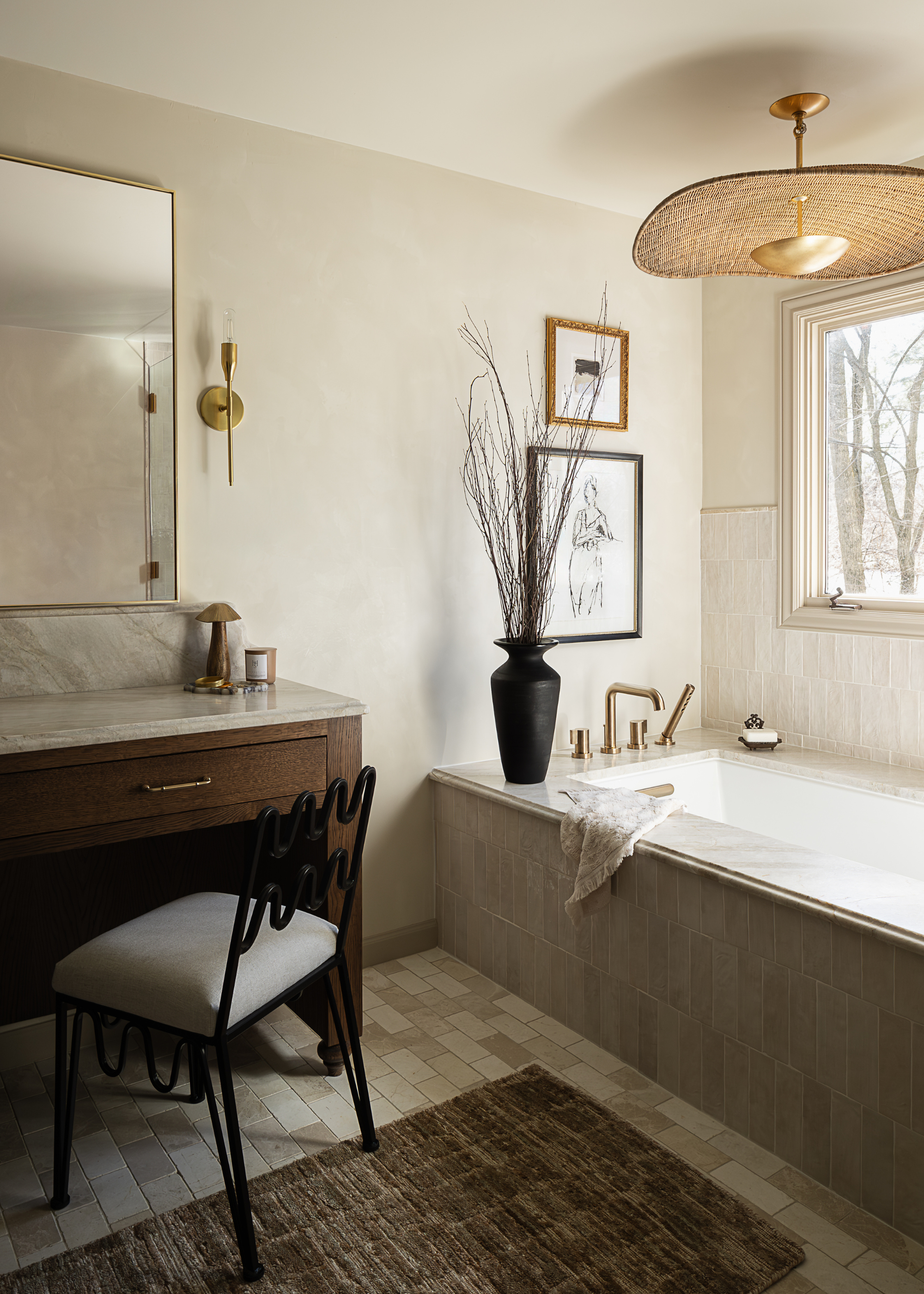 beautiful, neutral bathroom with dark wooden cabinets and gold handles, marble counter and gold accessories and a built in tiled bath