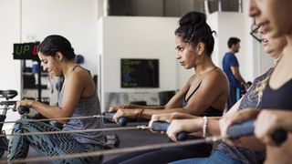 A group of women using rowing machines