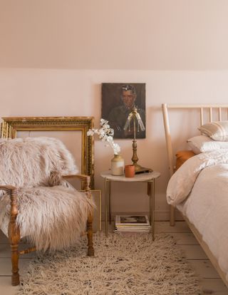 Rustic bedroom with pale pink walls, fur throws and vintage furniture
