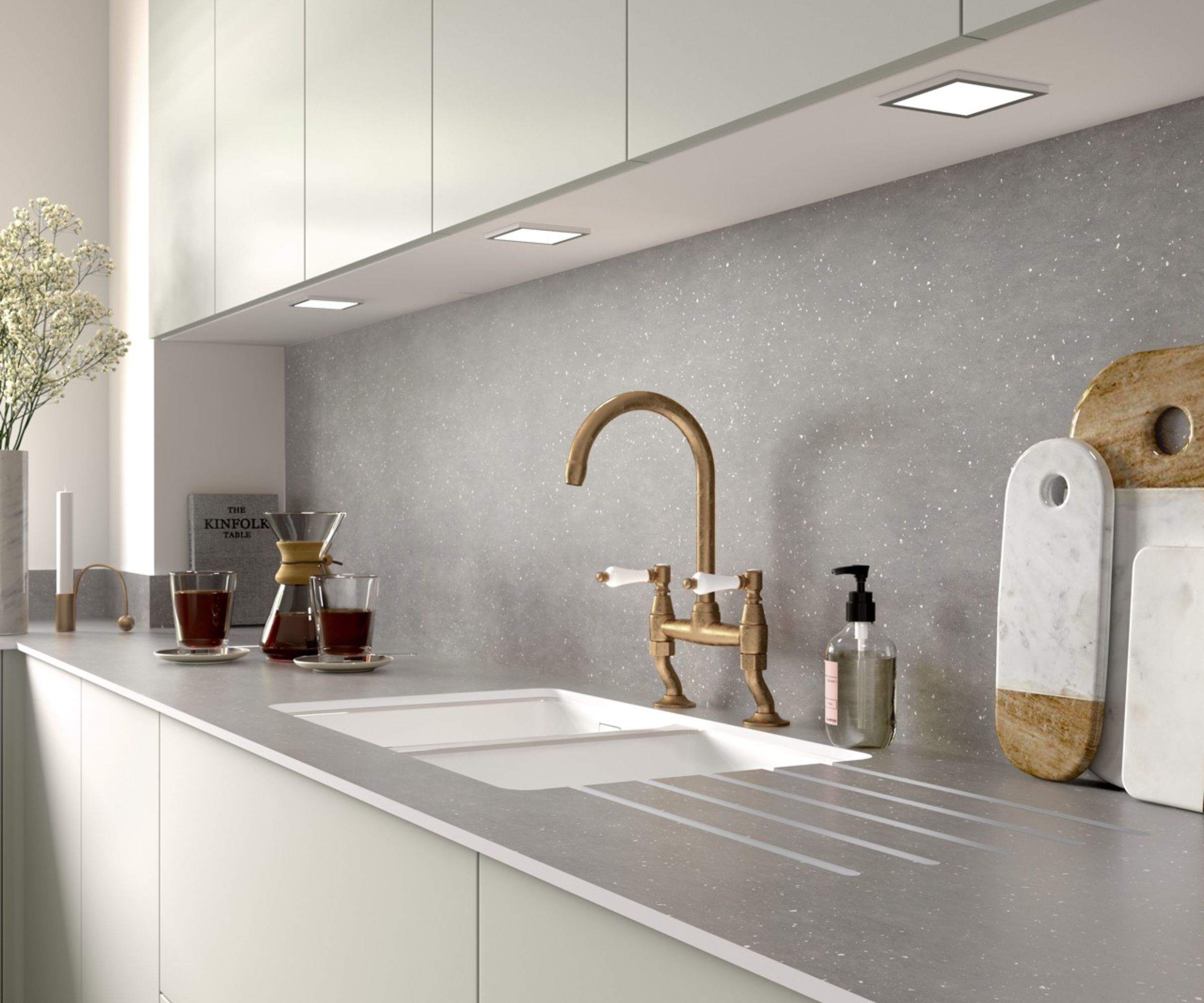 Minimalist white kitchen with a light grey quartz-effect worktop and integrated drainer grooves.