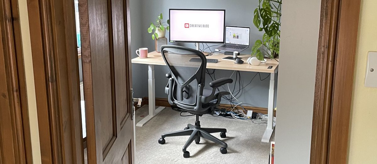 A photo through a doorframe, showing an office set up, including the Herman Miller Aeron chair. 