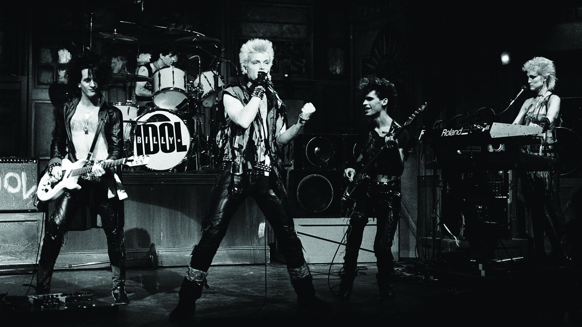 Billy Idol performs “Rebel Yell” on Saturday Night Live, hosted by comedian Don Rickles that night, January 28, 1984. Idol, Stevens and the group also played the 1982 hit “White Wedding.”