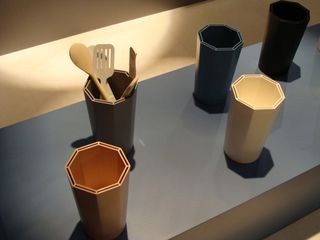 Five octagonal multi-coloured holders, with one storing cooking utensils.