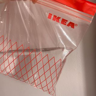 plastic bag with half filled bag with water on white wall