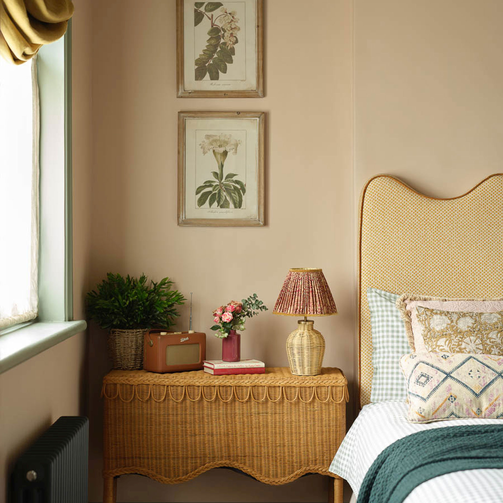 Pink bedroom with yellow headboard and rattan bedside table and table lamp