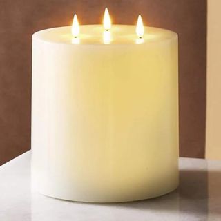 An ivory white 3-wick flameless candle.