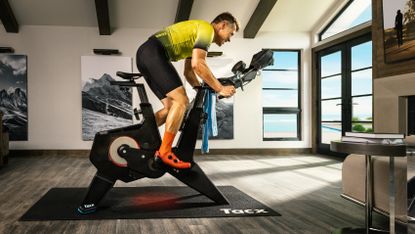 Man on a Tacx Neo Bike Plus in a bright room