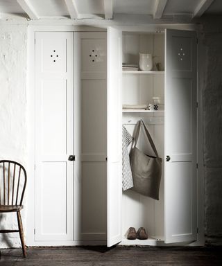 Alcove utilized as storage with rustic painted doors added