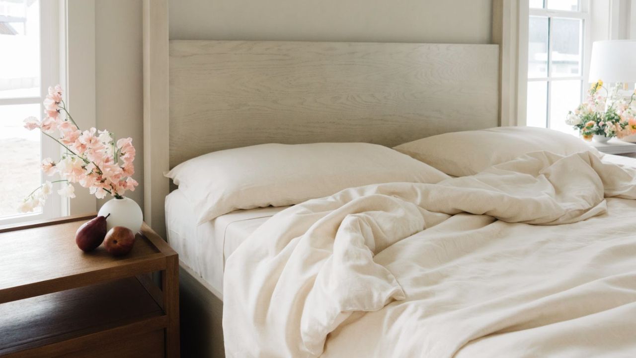 Cozy Earth bedding on a bed next to a nightstand.