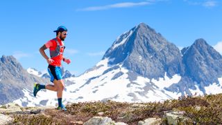 trail running vs road running: trail runner and mountain background