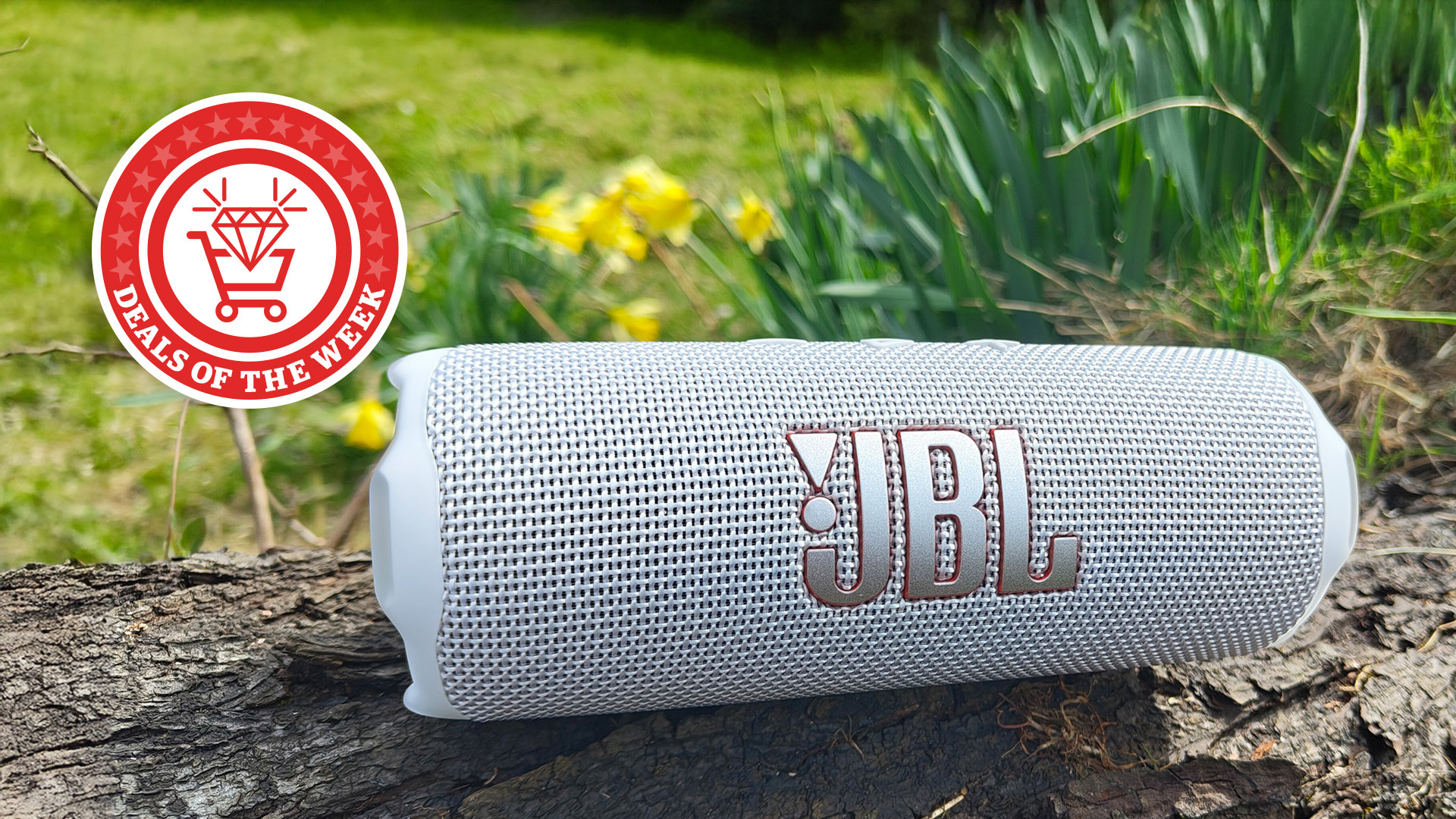 A close-up of the white JBL Flip 7 on a log, with the Deals of the Week logo overlayed above.