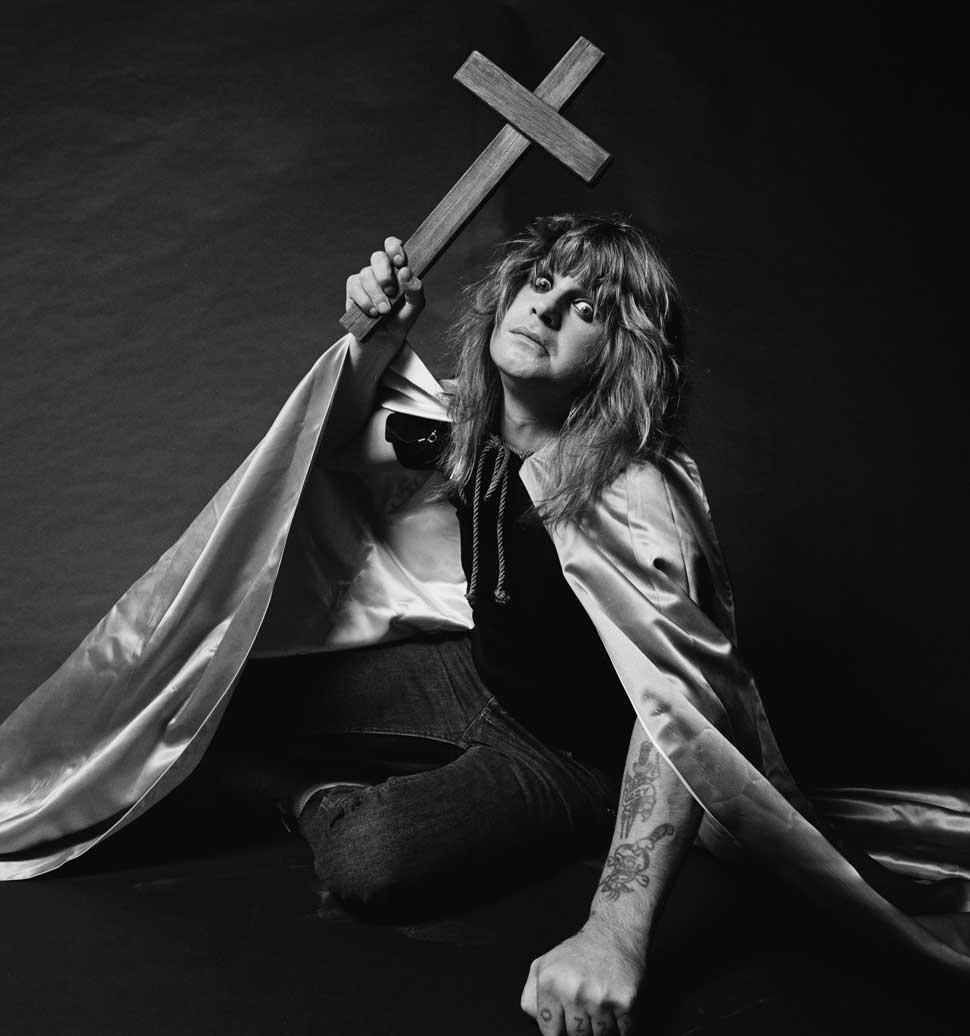 Ozzy Osbourne in a cloak, brandishing a crucifix